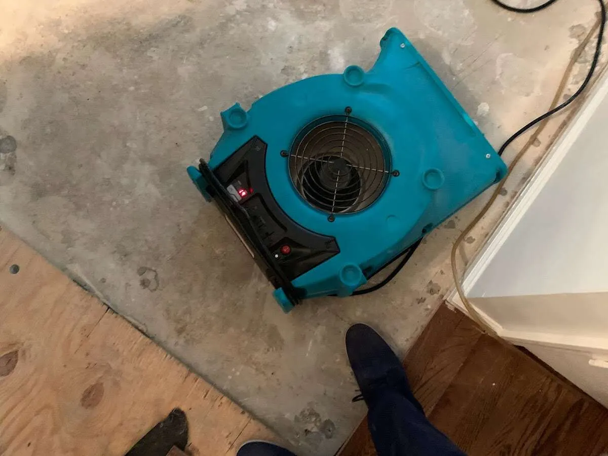Air mover drying subfloor during Commercial Water Damage Restoration in Ada